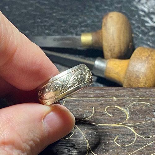 Hand engraved scroll pattern on white gold wedding band