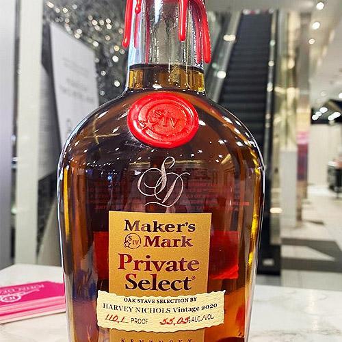 A monogram with intertwined initials hand engraved on a bottle of bourbon at an in-store event