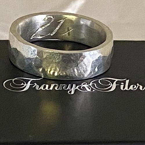A silver ring hand engraved for a 21st Birthday on the inner side of the ring
