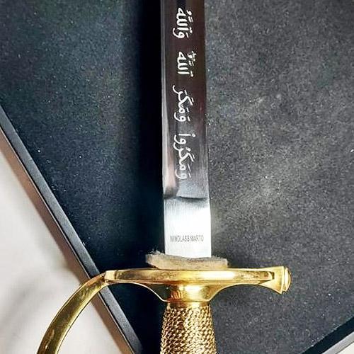 Oriental sword machine engraved with Arabic script on the swords sharp blade